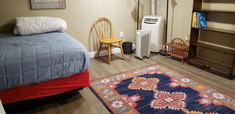 Bedroom showing rug and air conditioner